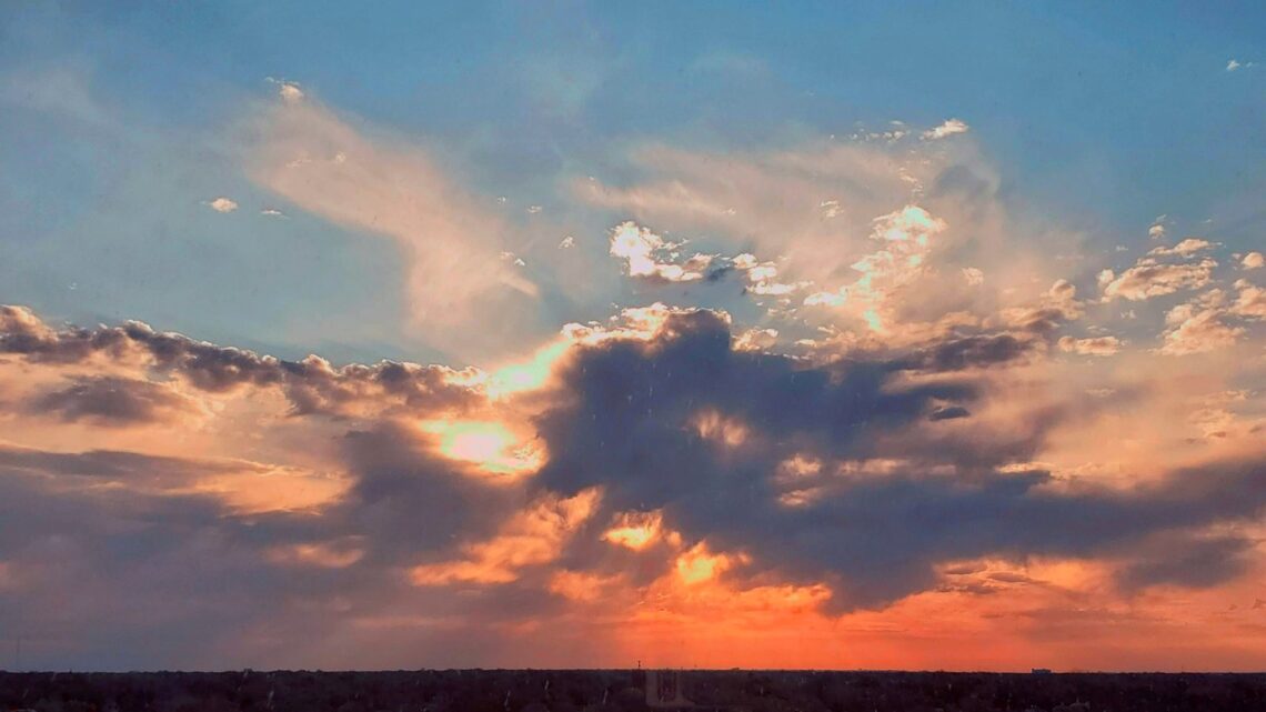 soft sunset light breaking through clouds over the horizon